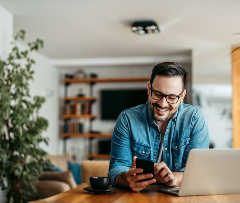 Mężczyzna przy biurku wpatrzony w telefon