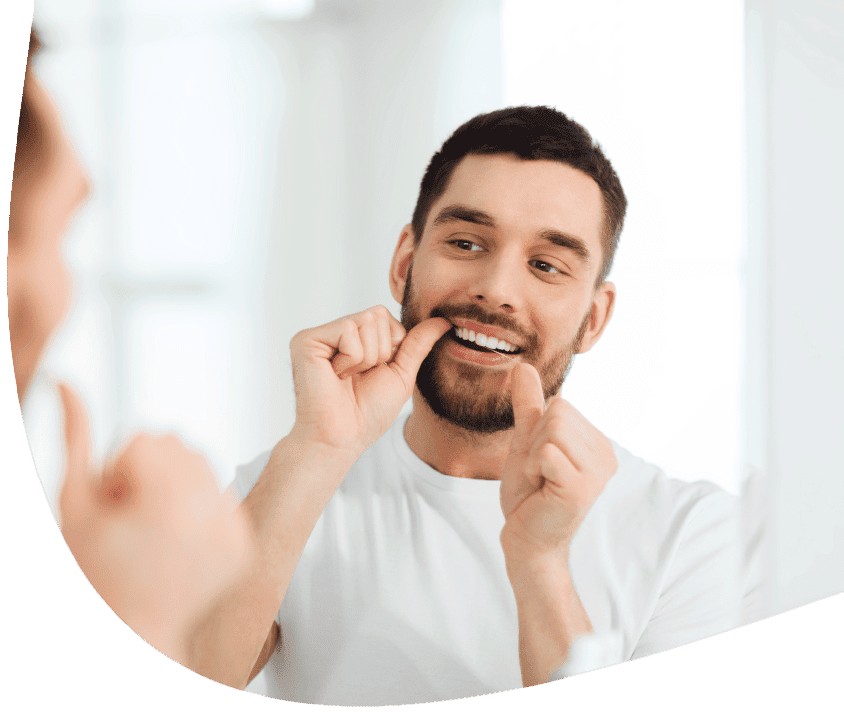 Mężczyzna myje zęby przed lustrem