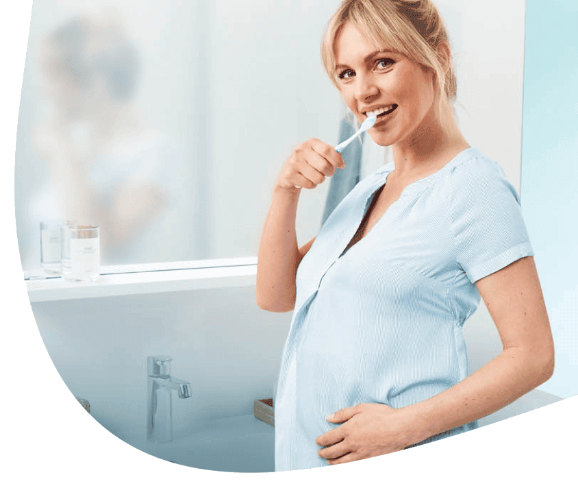 Kobieta w ciąży szczotkuje zęby w łazience