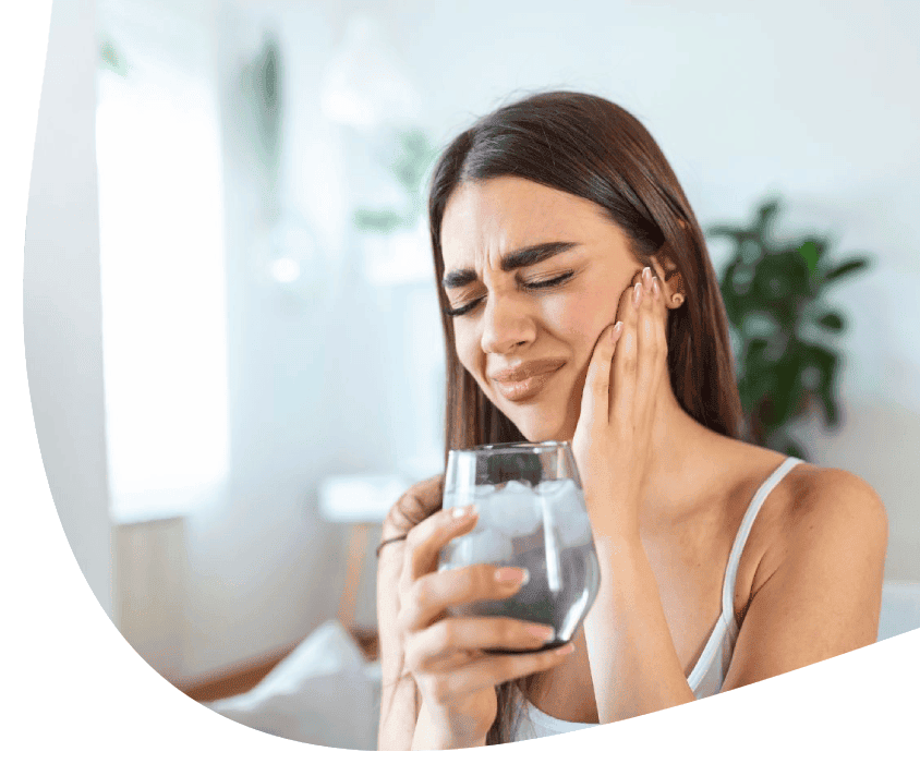 Wrażliwe dziąsła u młodej kobiety po wypiciu wody z lodem