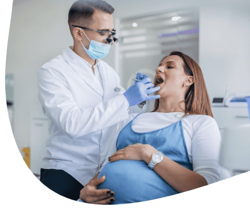 Kobieta w ciąży na fotelu dentystycznym podczas przeglądu